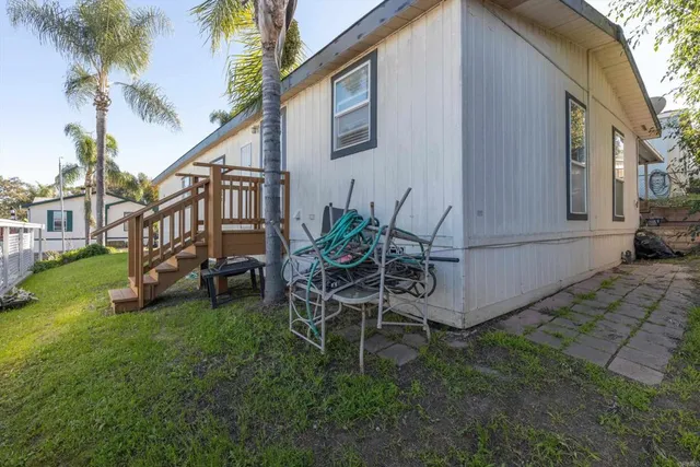 a view of a chair and table in backyard of the house