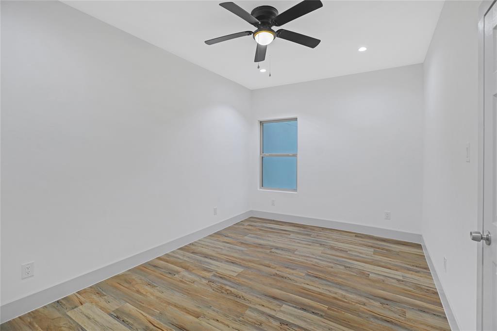 2606 Fordham Road Dallas, TX 75216 - Photo 17 of 19 Spacious room featuring wood-finish flooring, a contemporary ceiling fan, recessed lighting, and a window for natural light
