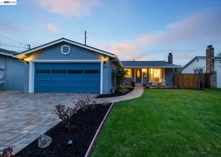 a living room with furniture a large window and wooden floor