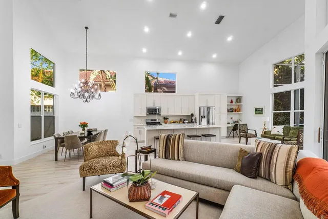 a living room with stainless steel appliances granite countertop a sink stove and wooden floor