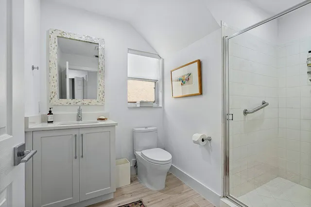 a bedroom with a bed a dresser next to a window