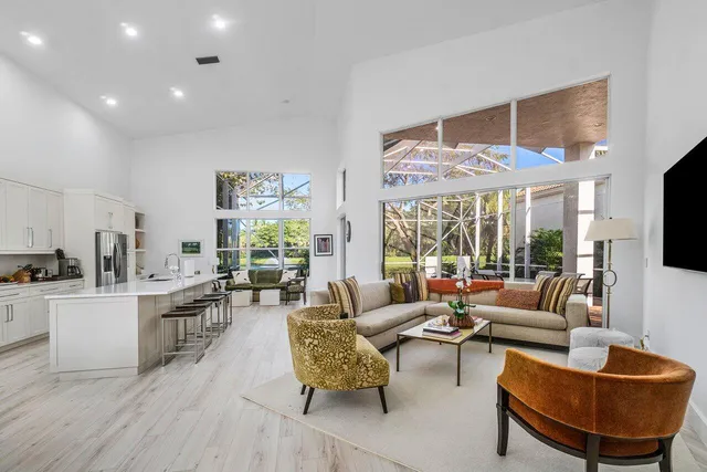 a living room with furniture wooden floor and a large window