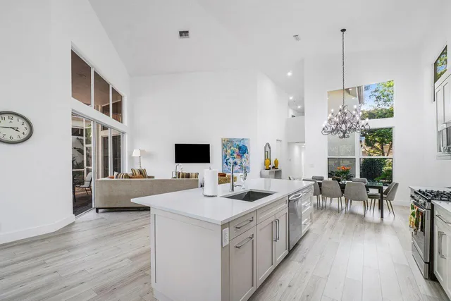 a view of living room kitchen with stainless steel appliances furniture stove and wooden floor