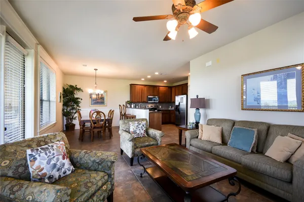 a living room with furniture kitchen view and a large window