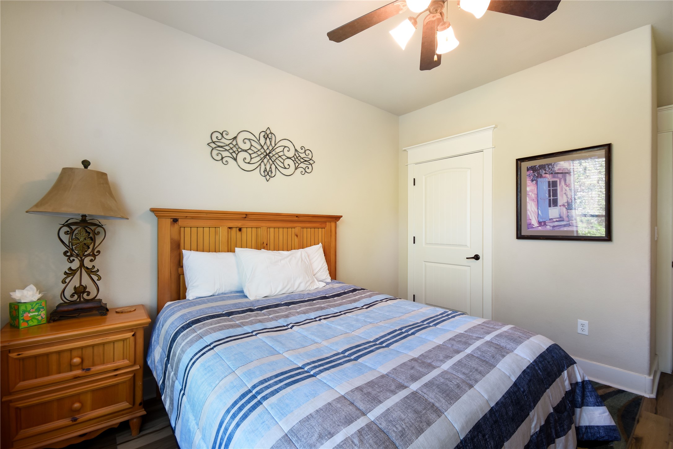 17800 Edgewood Way, Unit 203 Jonestown, TX 78645 - Photo 18 of 40 a bedroom with a large bed and a chandelier