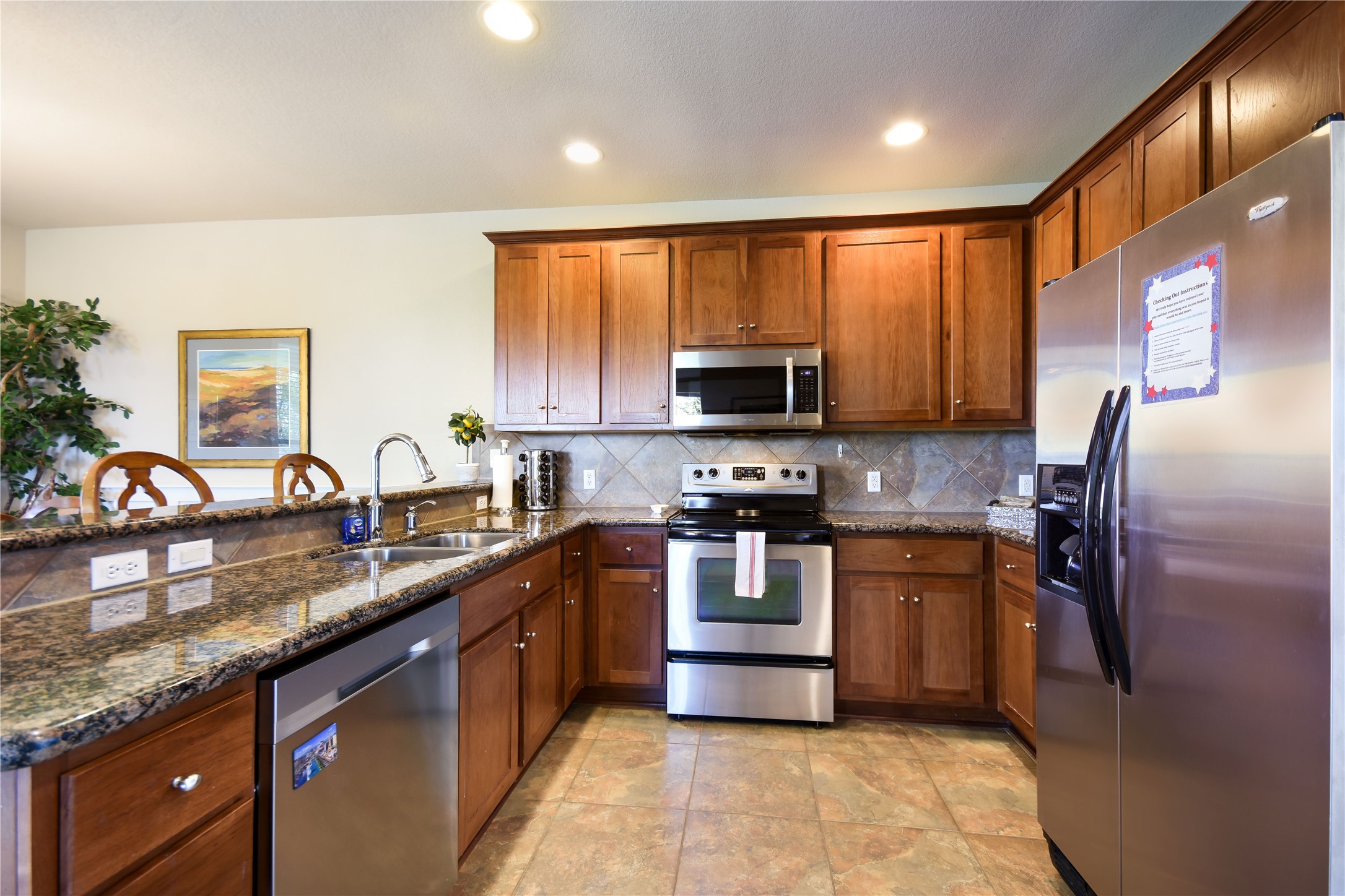 17800 Edgewood Way, Unit 203 Jonestown, TX 78645 - Photo 6 of 40 a kitchen with stainless steel appliances granite countertop a refrigerator a stove top oven a sink and dishwasher