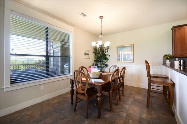 a view of a dining room and kitchen with a table chairs