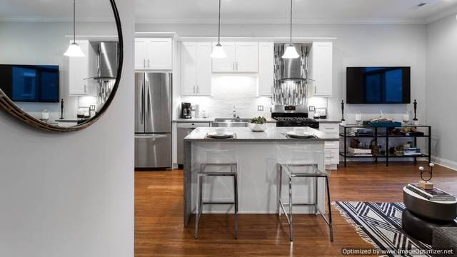 Undisclosed Address Chicago, IL 60607 - Photo 5 of 10 a kitchen with kitchen island granite countertop a stove a sink and a flat screen tv