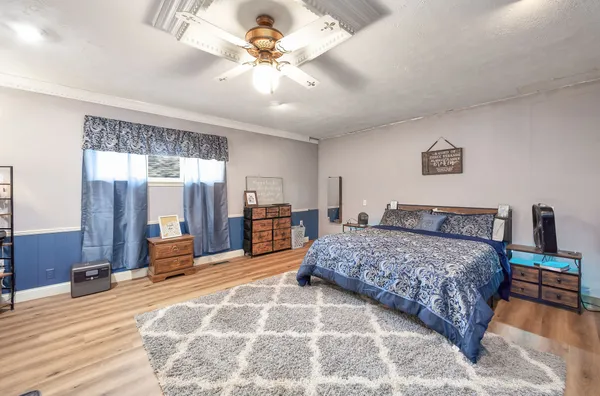 a spacious bedroom with a large bed and a chandelier