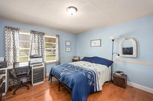 a bedroom with a bed and wooden floor
