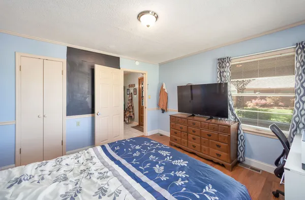 a bedroom with a bed and a flat screen television