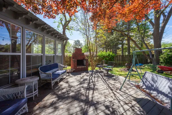a view of backyard with seating space and wooden fence
