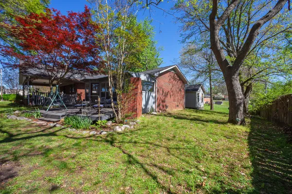 a view of backyard of house with green space