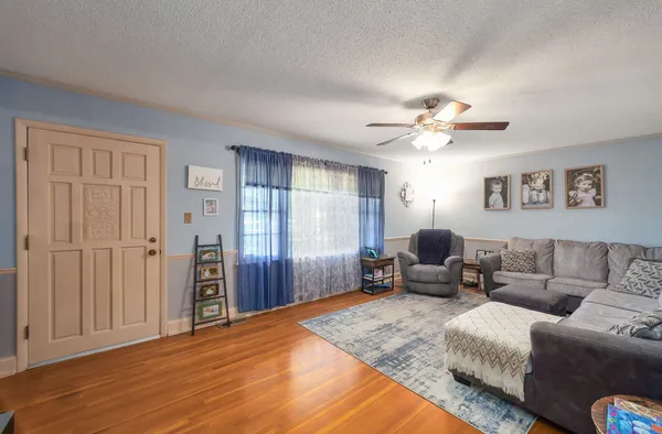a living room with furniture and a ceiling fan