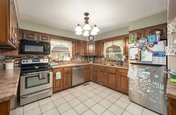 a kitchen with granite countertop stainless steel appliances a stove sink and microwave