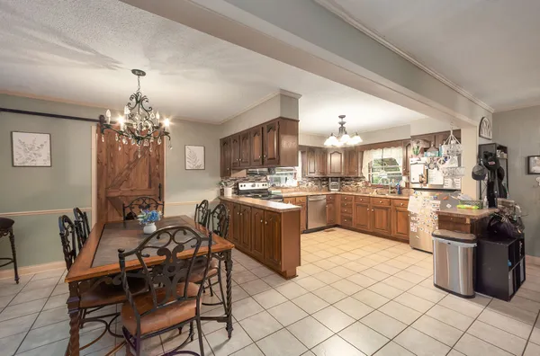 a kitchen with a chandelier dining table and chairs