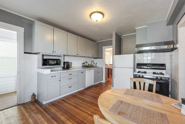 a kitchen with a refrigerator stove and white cabinets