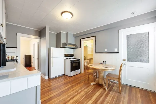 a kitchen with a table chairs refrigerator and microwave