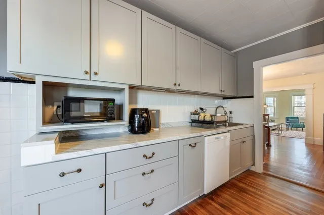 a kitchen with granite countertop white cabinets and stainless steel appliances