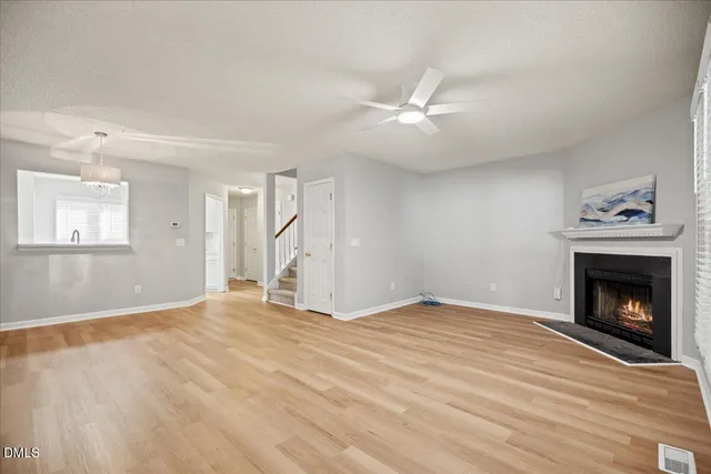 a view of empty room with fan and fireplace