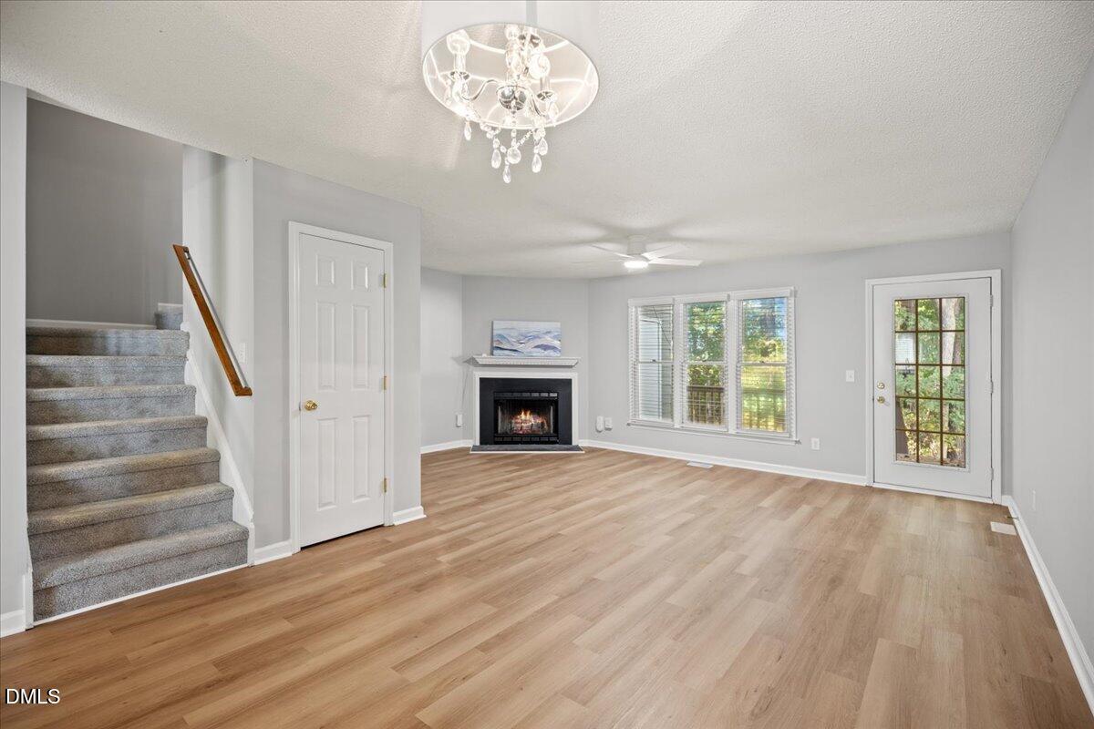 6063 Epping Forest Drive Raleigh, NC 27613 - Photo 13 of 34 a view of an empty room with wooden floor fireplace and a window