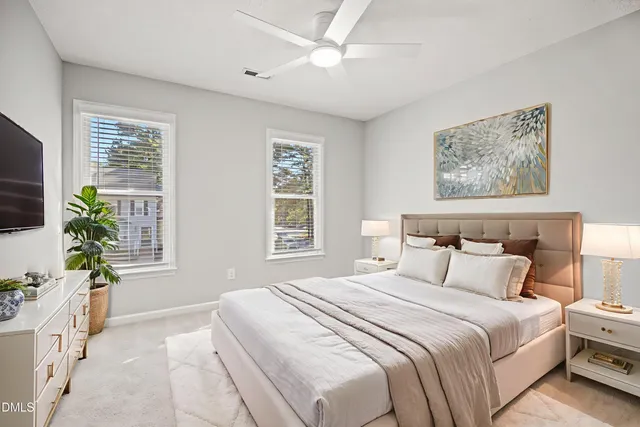 a bedroom with a large bed a chandelier and a window