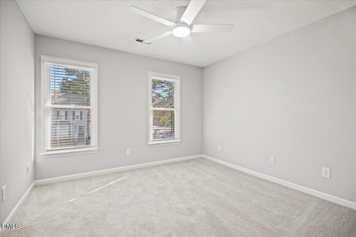 6063 Epping Forest Drive Raleigh, NC 27613 - Photo 16 of 34 an empty room with windows and fan