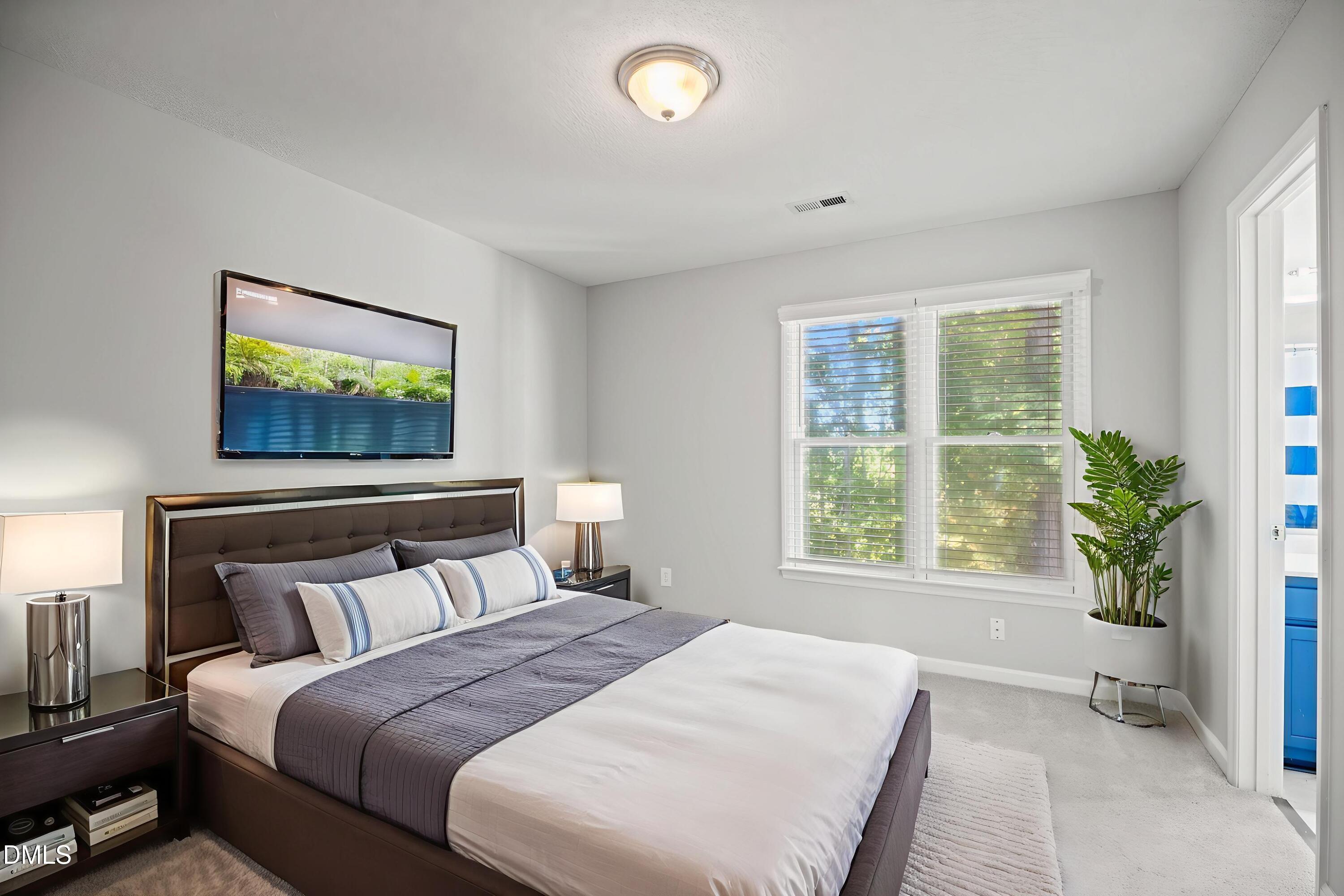 6063 Epping Forest Drive Raleigh, NC 27613 - Photo 20 of 34 a bedroom with a large bed and a large window