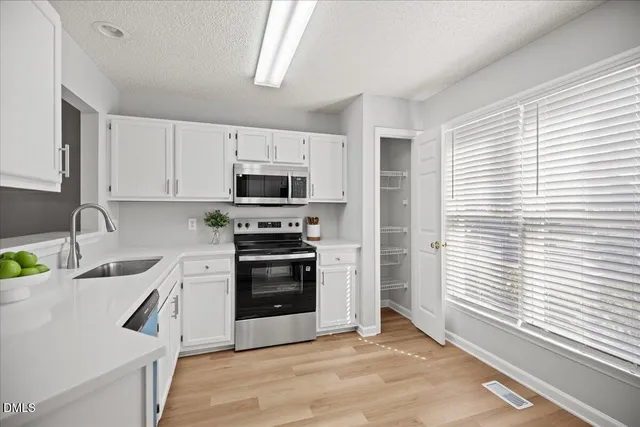 a kitchen with a sink a stove and cabinets