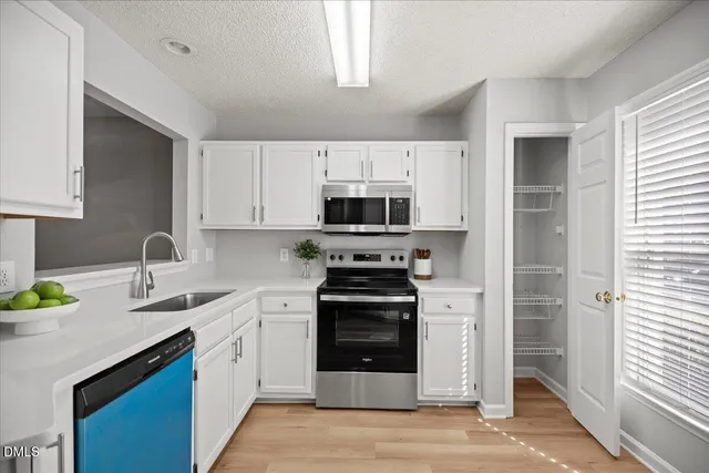 a kitchen with stainless steel appliances a stove a sink and a microwave