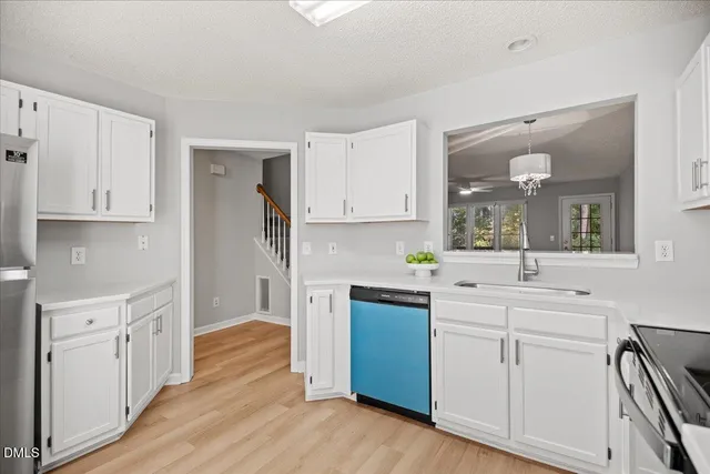 a kitchen with white cabinets and sink