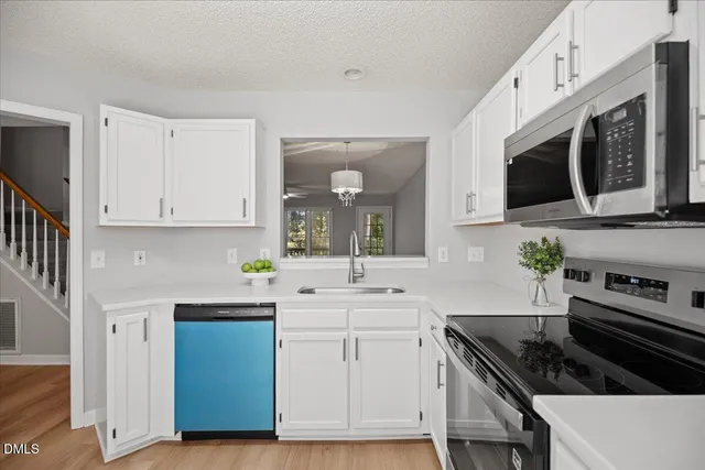 a kitchen with white cabinets and appliances