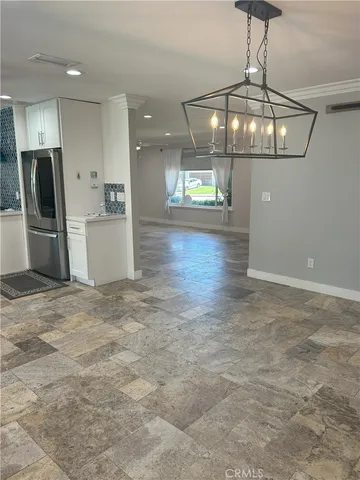 a kitchen with white cabinets and window