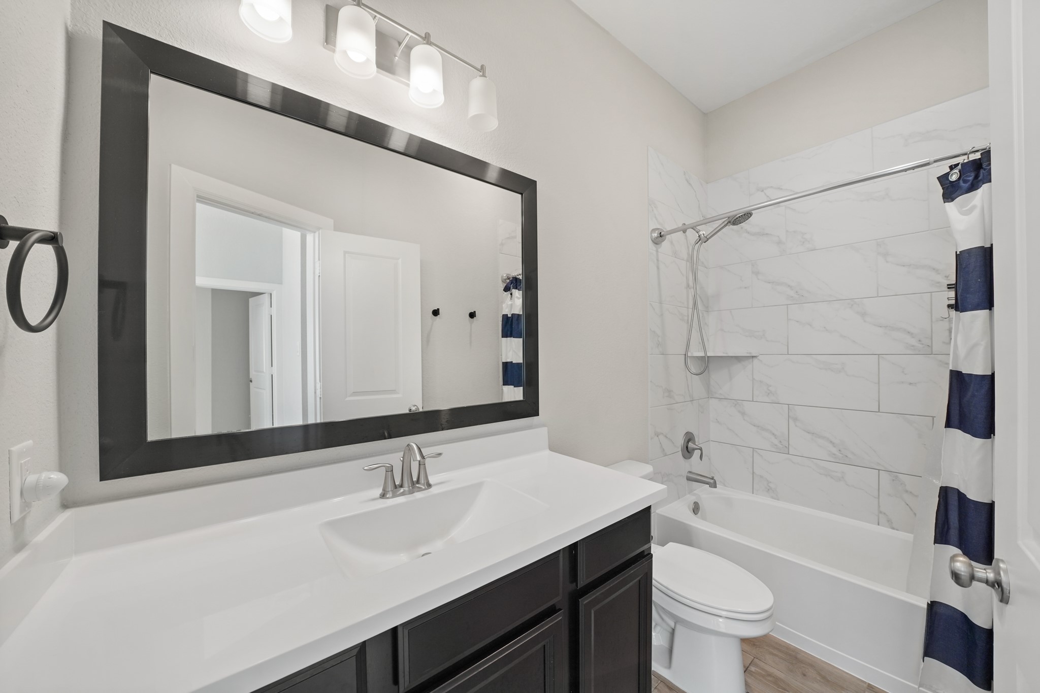 6635 Waxbill Road Katy, TX 77493 - Photo 21 of 33 a bathroom with a sink a toilet a mirror a vanity and bathtub