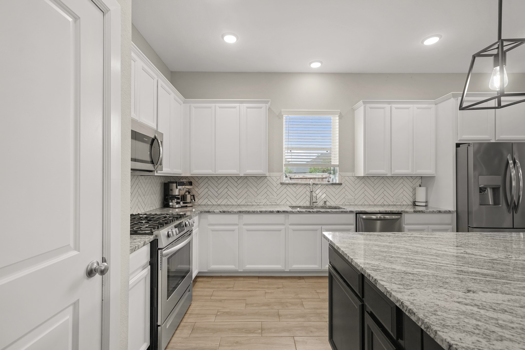 6635 Waxbill Road Katy, TX 77493 - Photo 9 of 33 a kitchen with stainless steel appliances granite countertop a sink stove and refrigerator