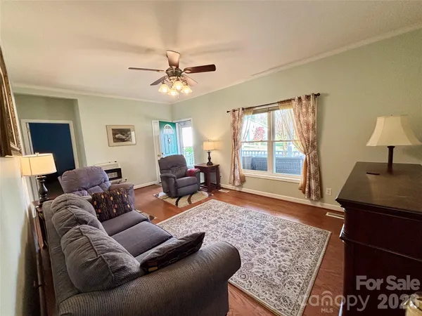 a kitchen with granite countertop kitchen island stainless steel appliances a stove a refrigerator a sink a dining table and chairs with wooden floor