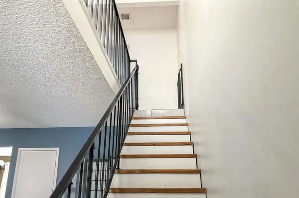 a view of a big room with wooden floor and windows
