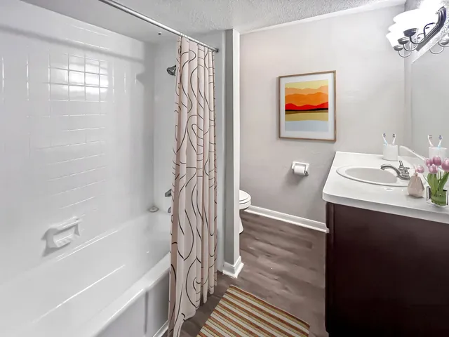 a bathroom with a sink a toilet and shower