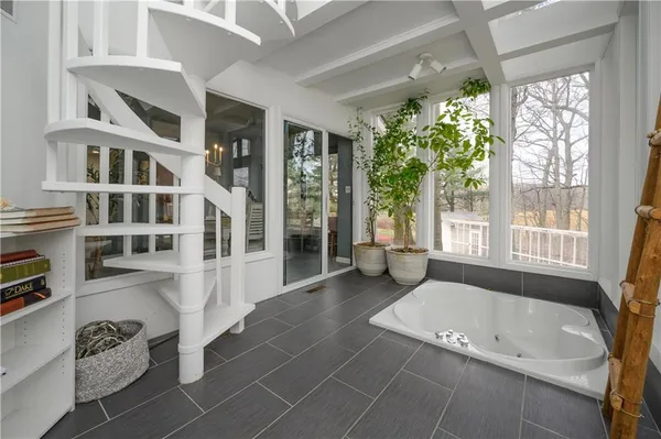 a spacious bathroom with a tub shower and windows