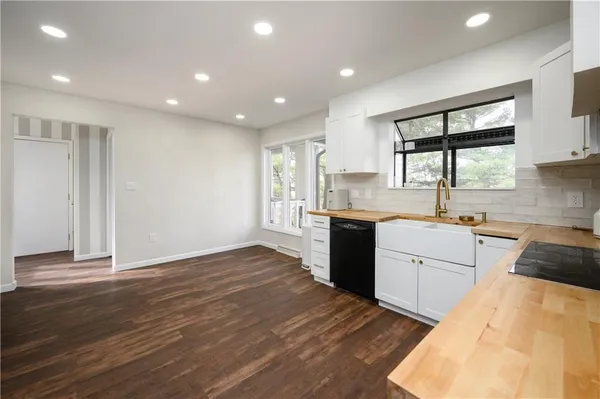 a large kitchen with granite countertop a large window and a sink