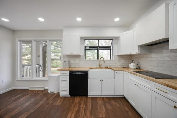 a kitchen with a sink wooden floor and stove top oven