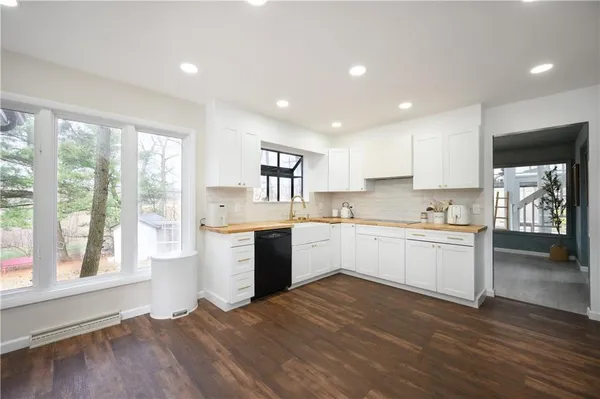 a kitchen with a refrigerator and white cabinets
