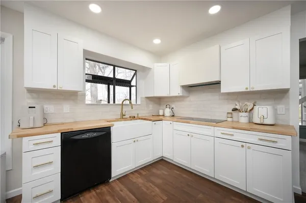 a kitchen with a sink dishwasher window and cabinets