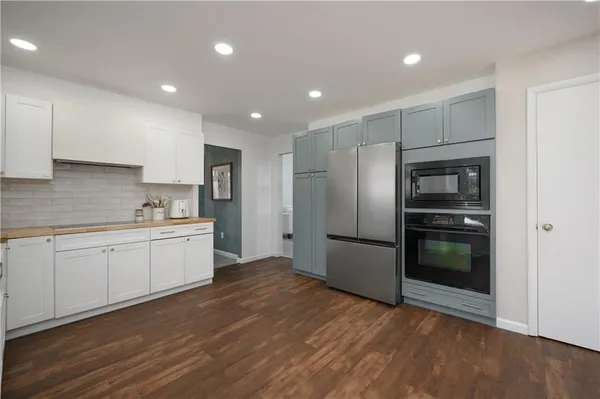 a kitchen with stainless steel appliances granite countertop a refrigerator and a stove top oven