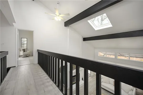 a view of a hallway with wooden floor and a chandelier
