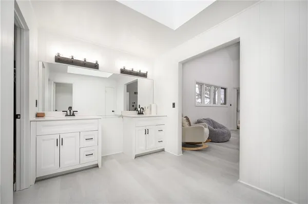 a spacious en suite bathroom with a double vanity sink and a mirror