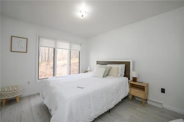 a large bed sitting in a bedroom next to a window
