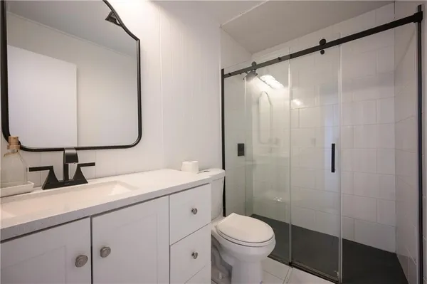 a bathroom with a sink a toilet and shower