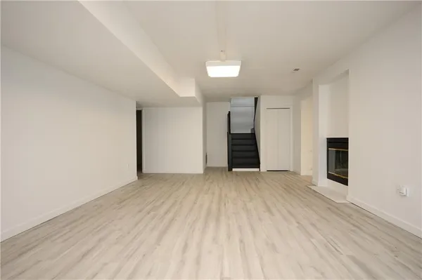 a view of an empty room with closet and a window