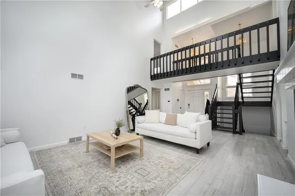a living room with furniture a rug and white walls